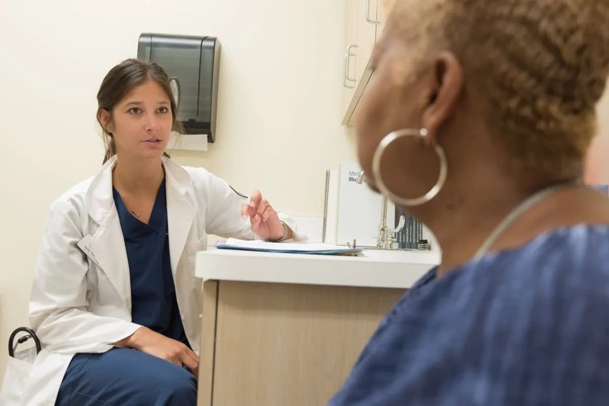 Médica conversando con una paciente en una consulta privada